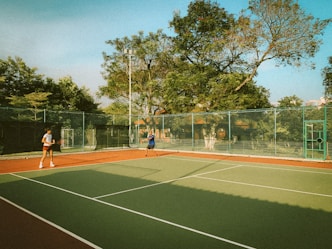 two people playing tennis on a tennis court