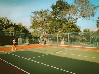 two people playing tennis on a tennis court