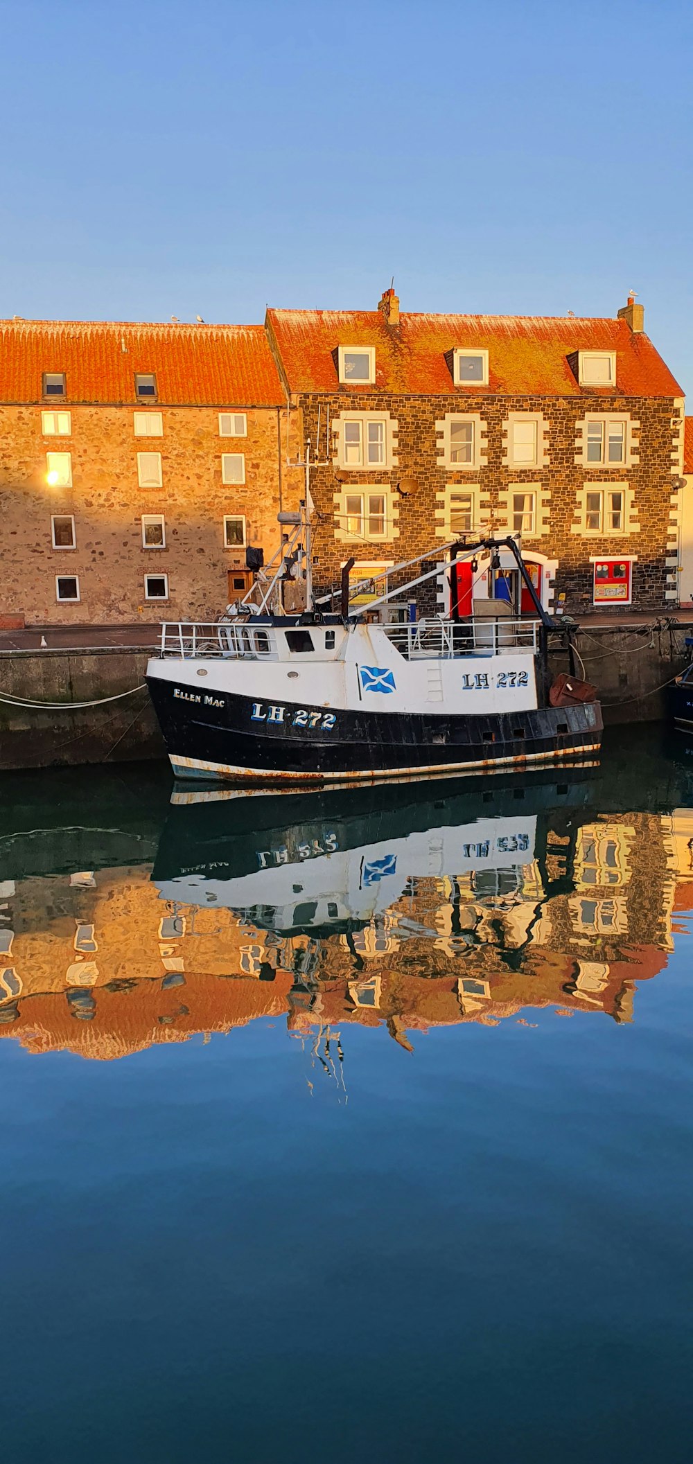 a boat is docked in the water next to a brick building