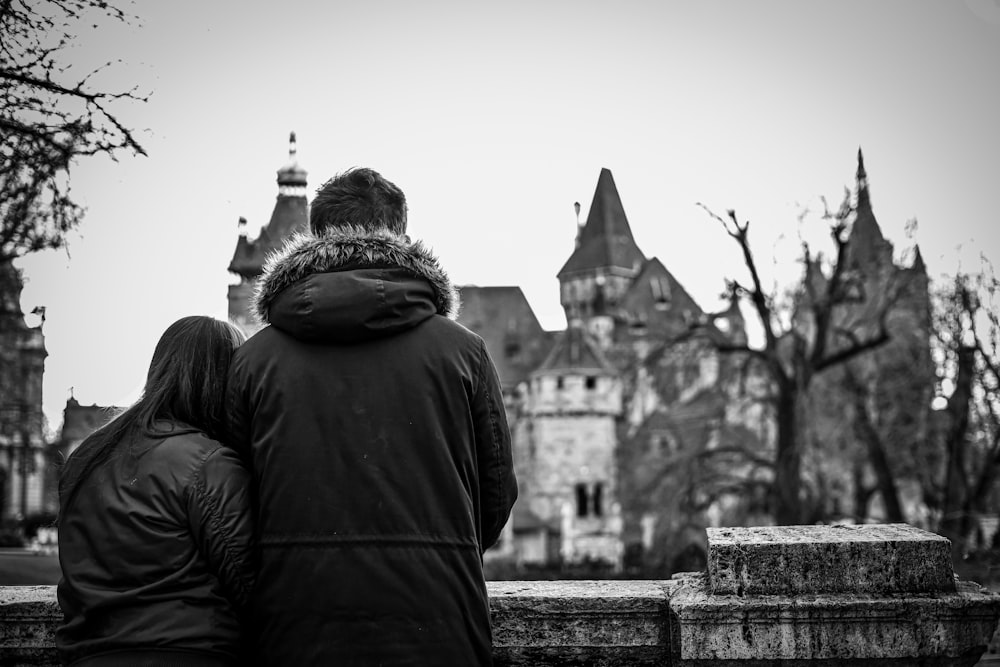 a couple of people that are standing in front of a castle