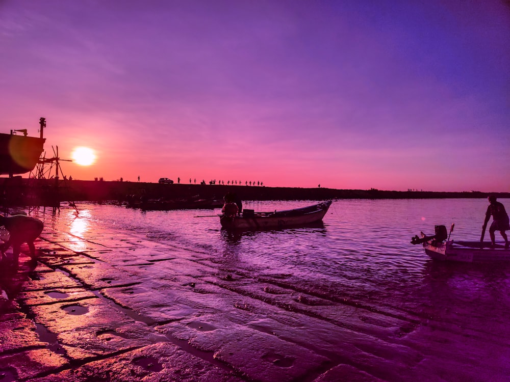 a person standing next to a boat on a body of water