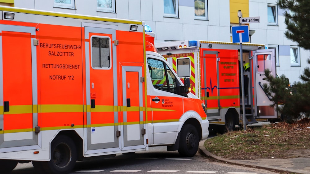 a couple of orange ambulances parked next to each other