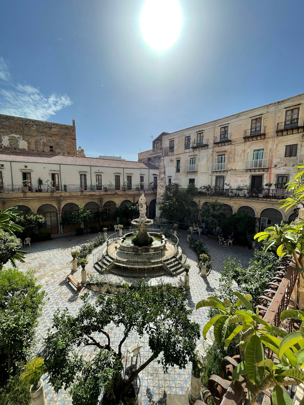 a courtyard with a fountain surrounded by trees