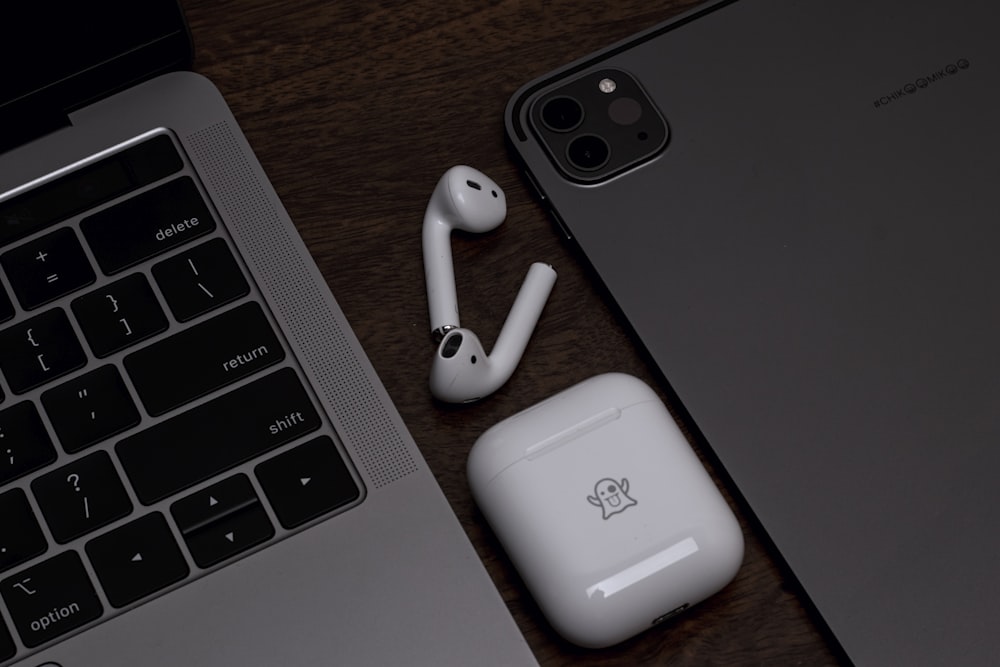 a pair of ear buds sitting next to a laptop
