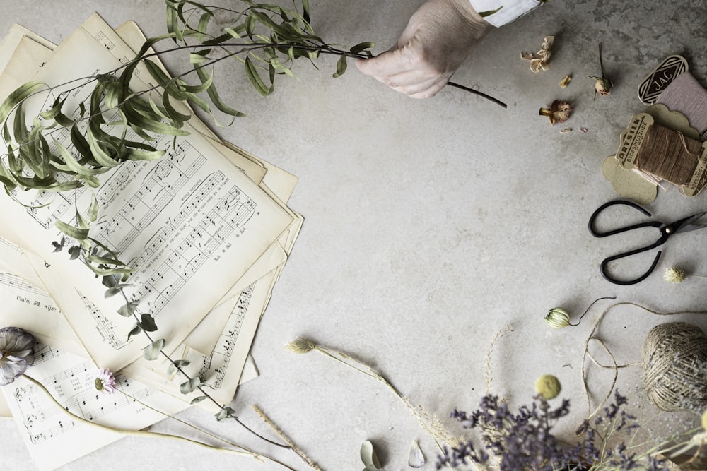 a table topped with lots of papers and flowers