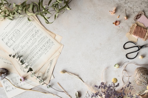 A spread of vintage sheet music pages laid out on a wooden table.