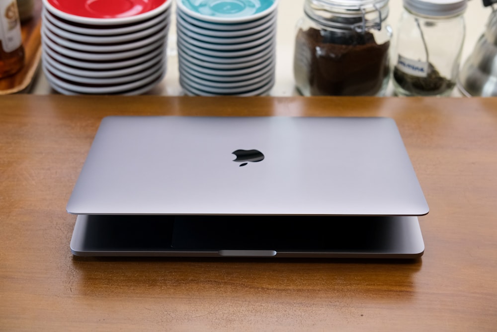 an apple laptop sitting on top of a wooden table