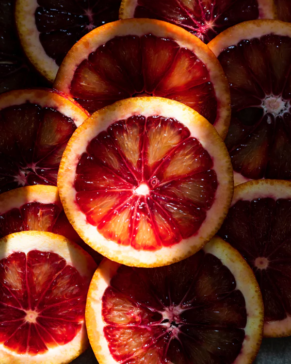 Aufgeschnittene Blutorange mit tiefrotem Fruchtfleisch in Nahaufnahme — der Blutorangen-Nektar im Herzen von Vendetta Donna, von der Parfumerie Olara