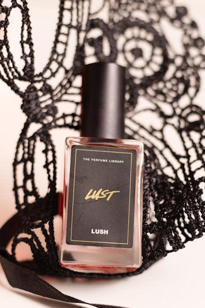 a bottle of perfume sitting on top of a black lace