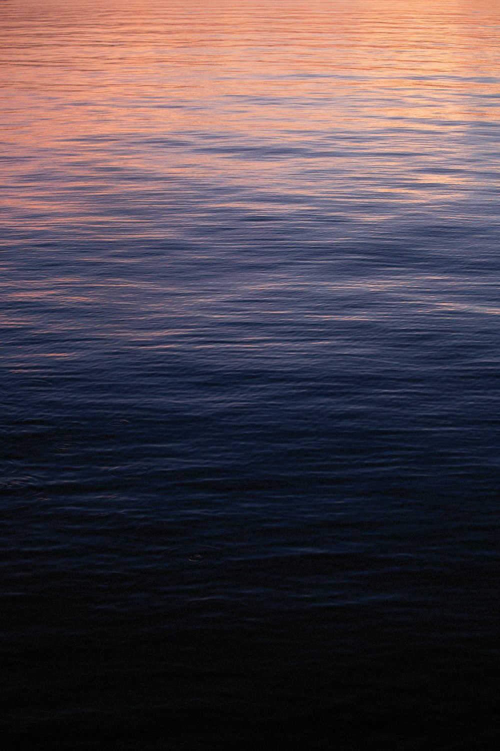 a large body of water with a boat in the distance