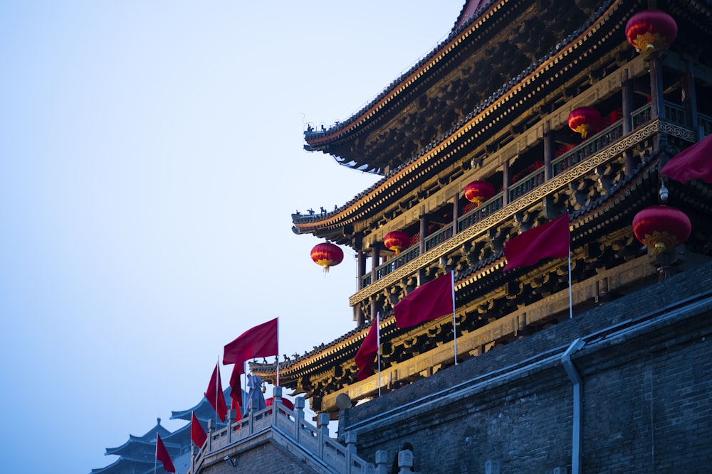 a tall building with red flags flying in front of it