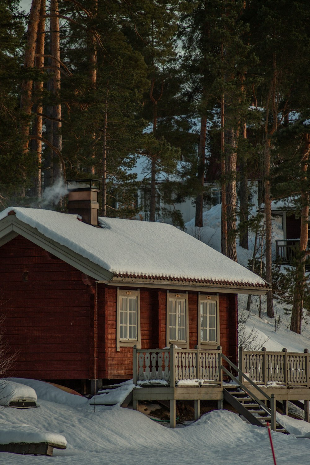 Eine Hütte im Wald mit Schnee auf dem Boden