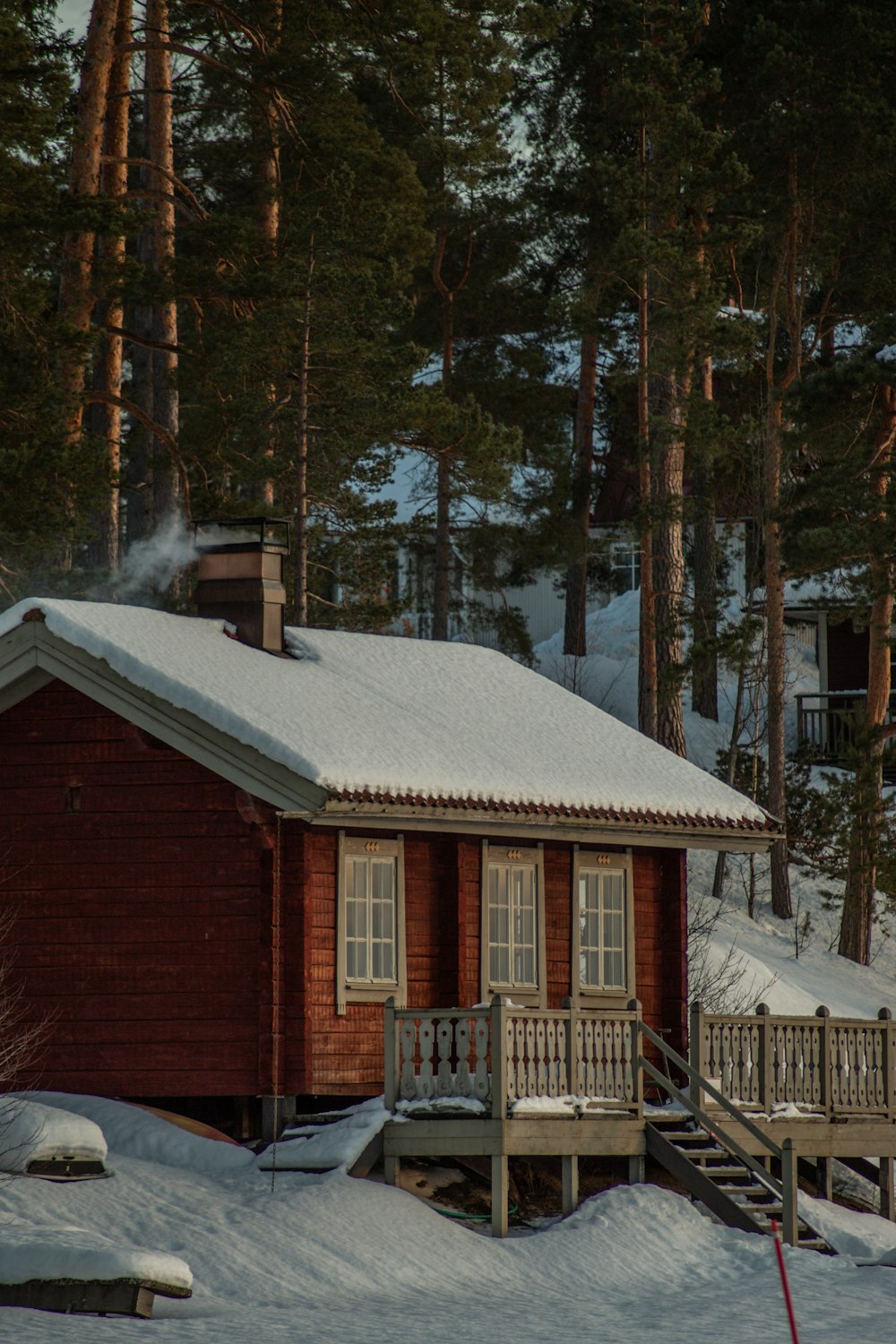 a cabin in the woods with snow on the ground