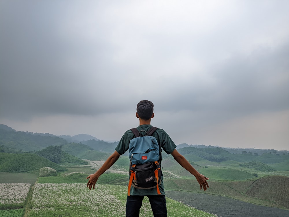 a man standing on top of a lush green hillside