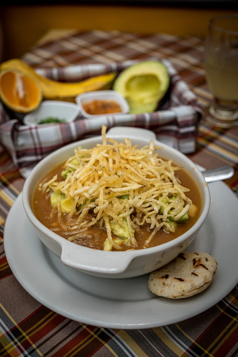 Sopa servida en plato hondo con papa crocante por encima
