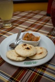 a white plate topped with food next to a bowl of salsa