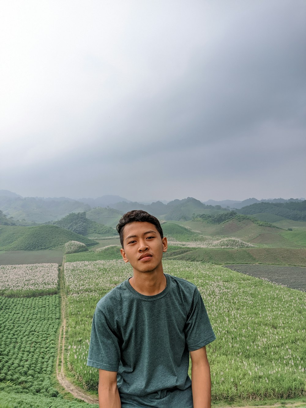 Un uomo in piedi di fronte a un campo verde lussureggiante