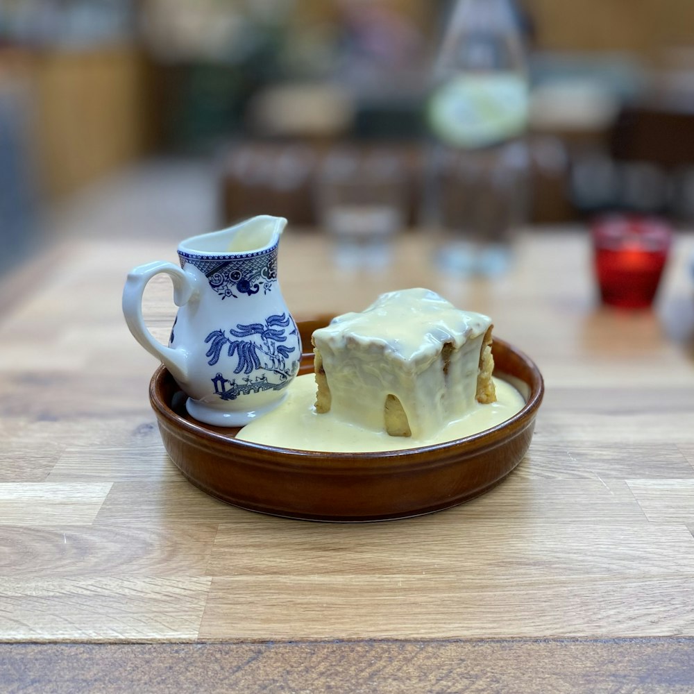 a plate of food with cream and a pitcher on it