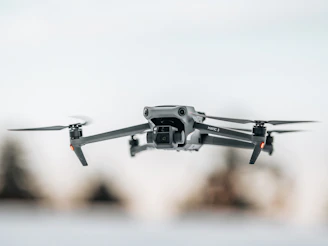 Close-up of a sleek racing drone mid-flight against a blurred urban background