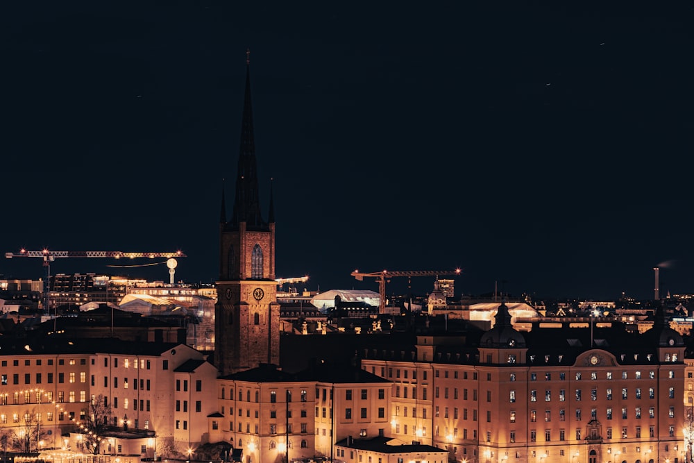 a night view of a city with a clock tower