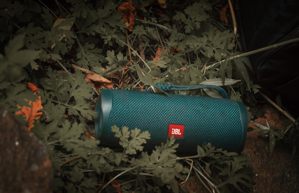 a blue jbl speaker laying on the ground