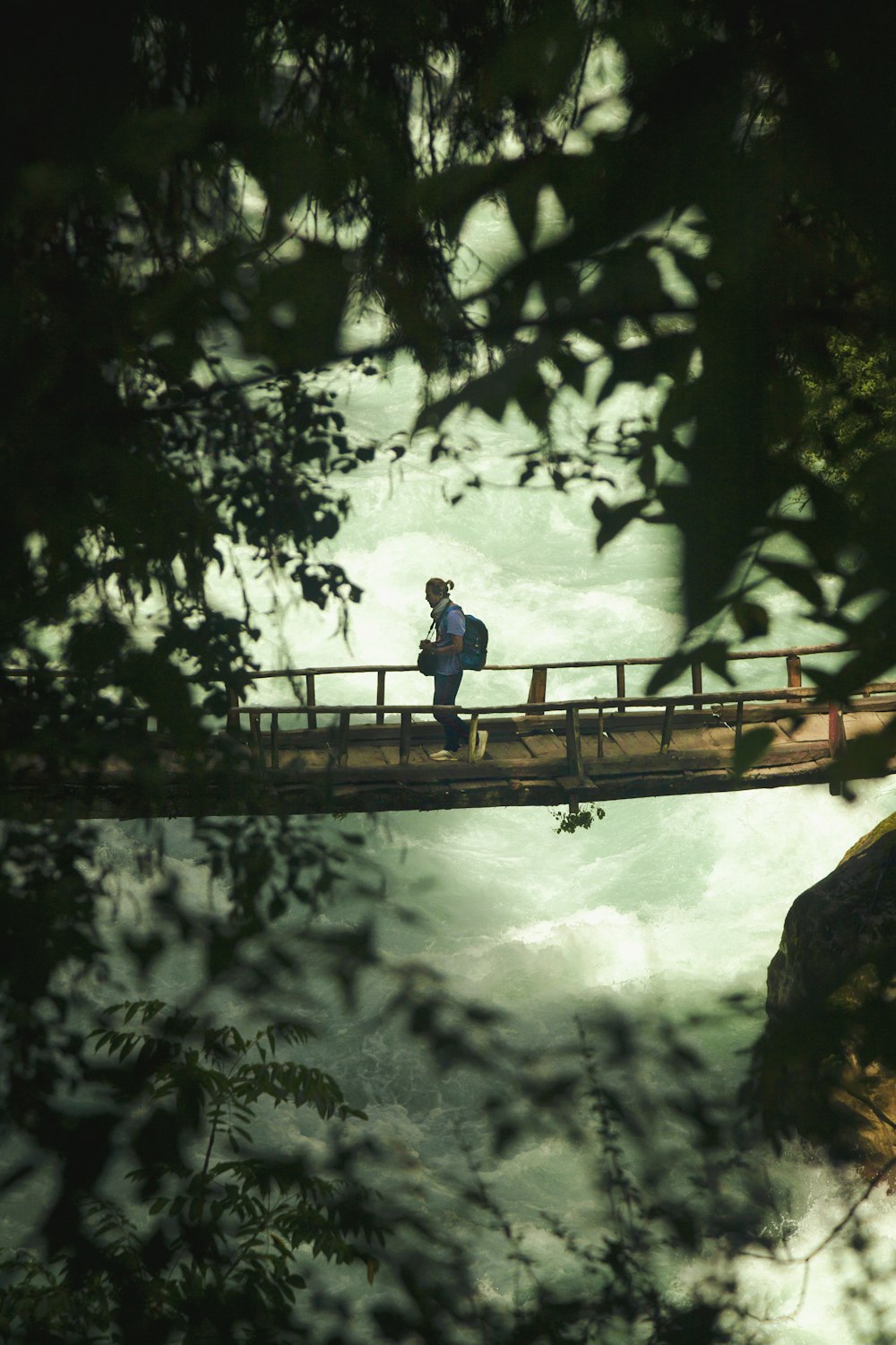 Un hombre caminando a través de un puente sobre un río