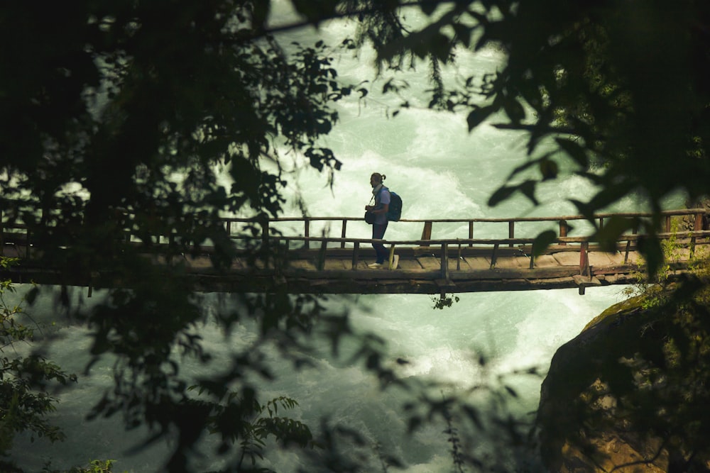 a man standing on a bridge over a river