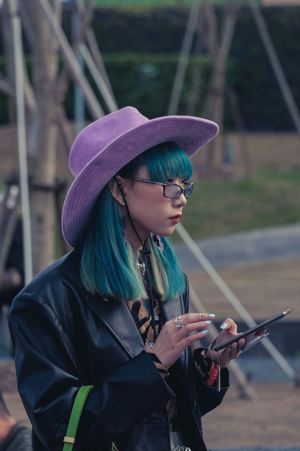 a woman with blue hair wearing a purple hat