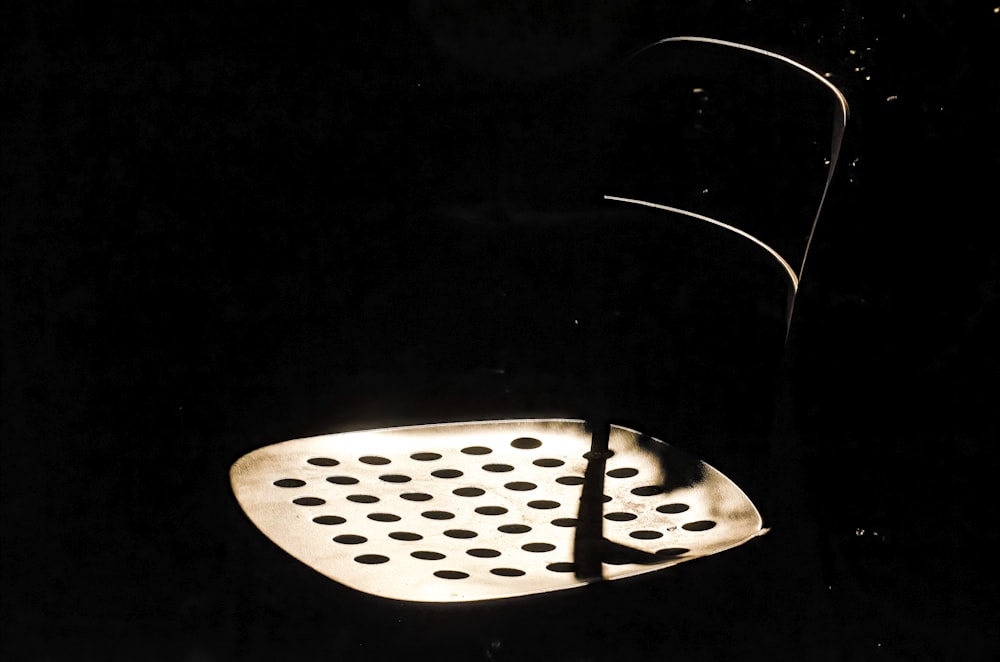 Una foto en blanco y negro de una silla en la oscuridad