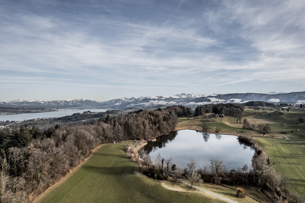 a view of a golf course with a lake and mountains in the background