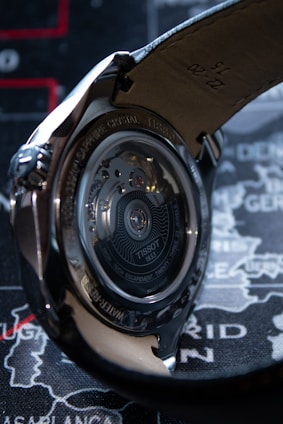 Elegant automatic watch showcasing its intricate movement through a transparent case back