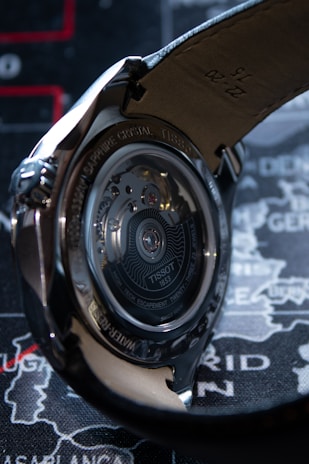 Detail of a watch’s intricate movement visible through a transparent case back, illuminated with soft light.