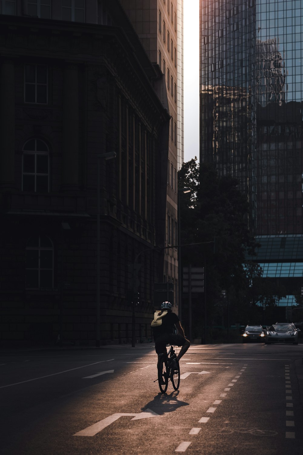 a man riding a bike down a street next to tall buildings