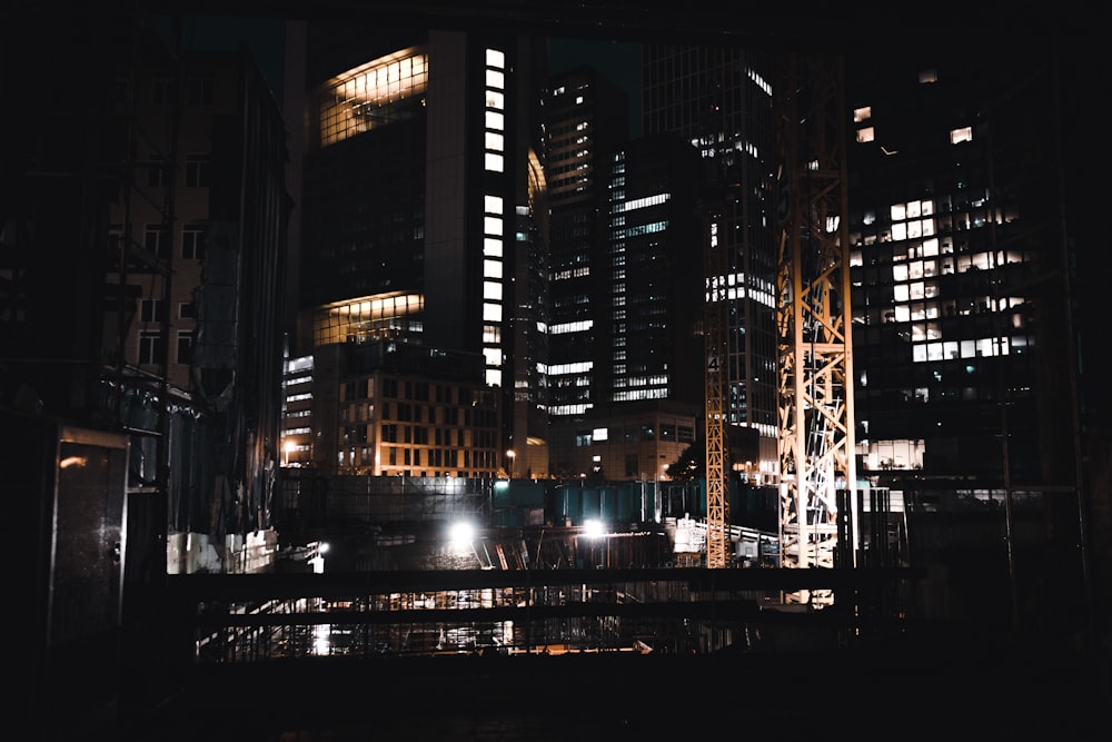 a night scene of a city with a bridge in the foreground