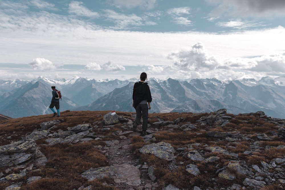 a couple of people standing on top of a mountain