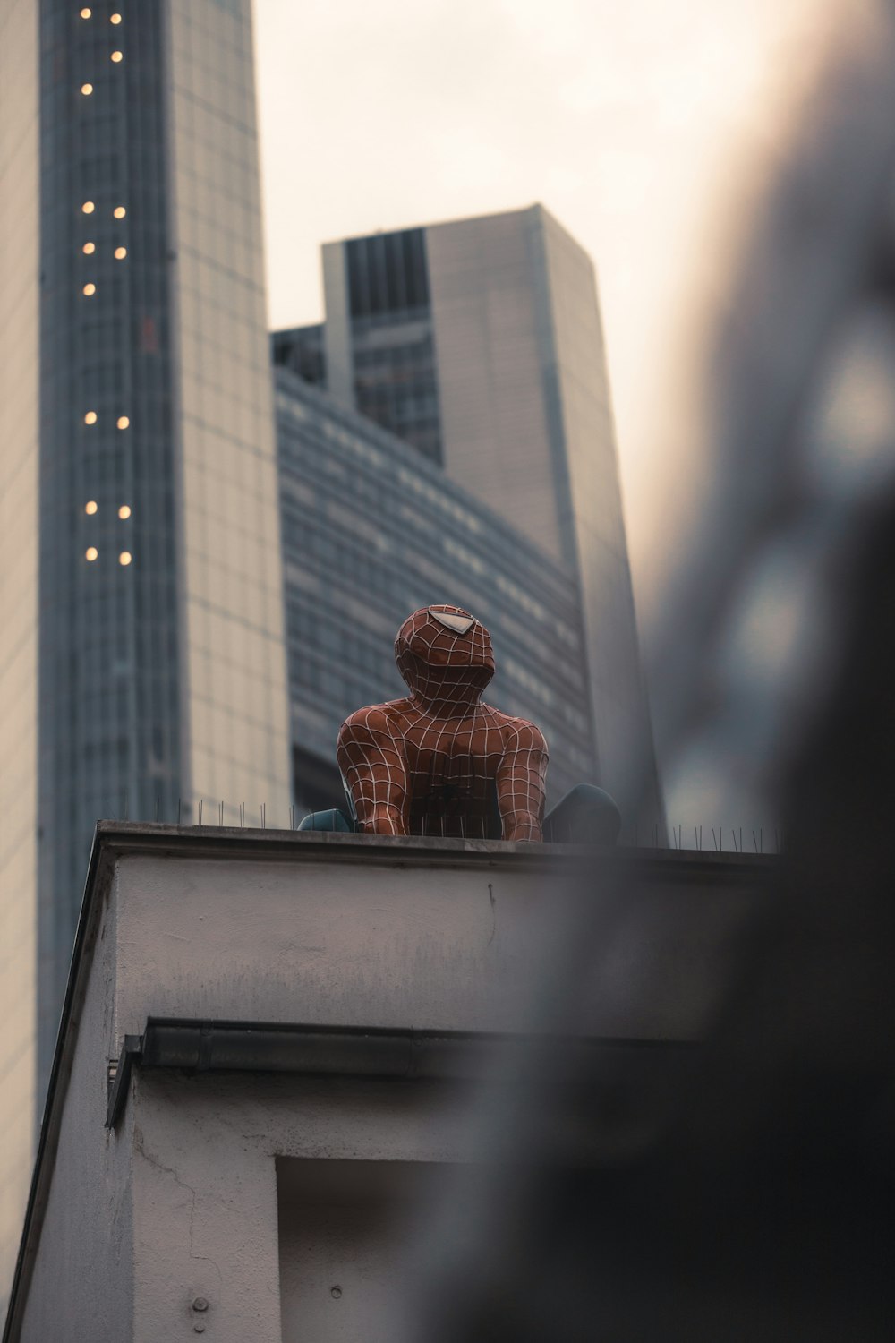 a man sitting on top of a roof next to a tall building