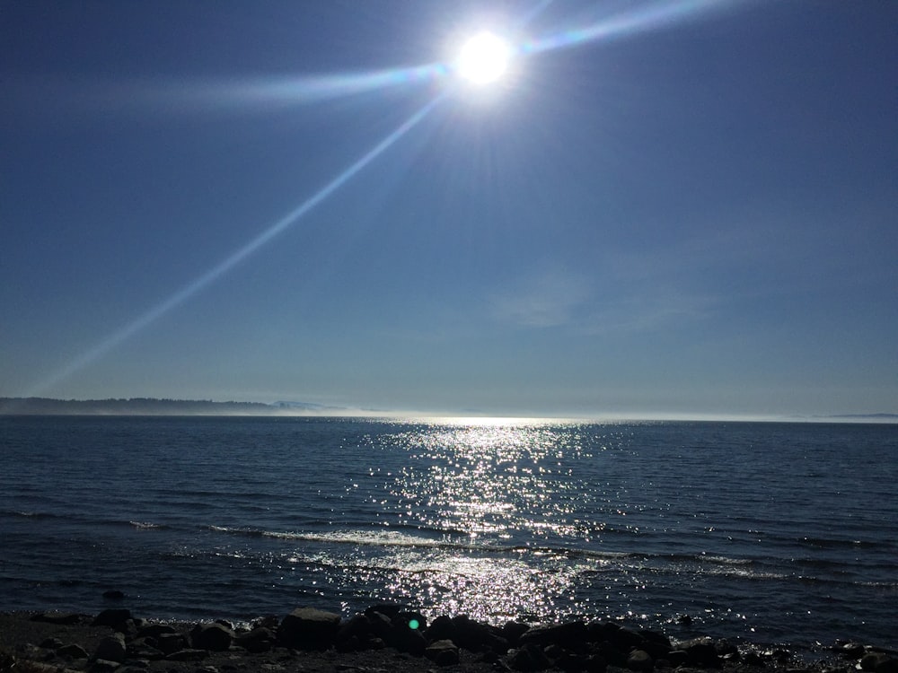 the sun shines brightly over the ocean on a clear day