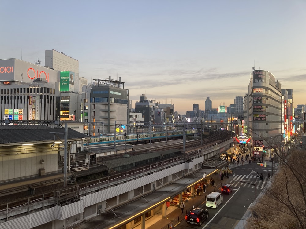 a busy city street with a train on the tracks