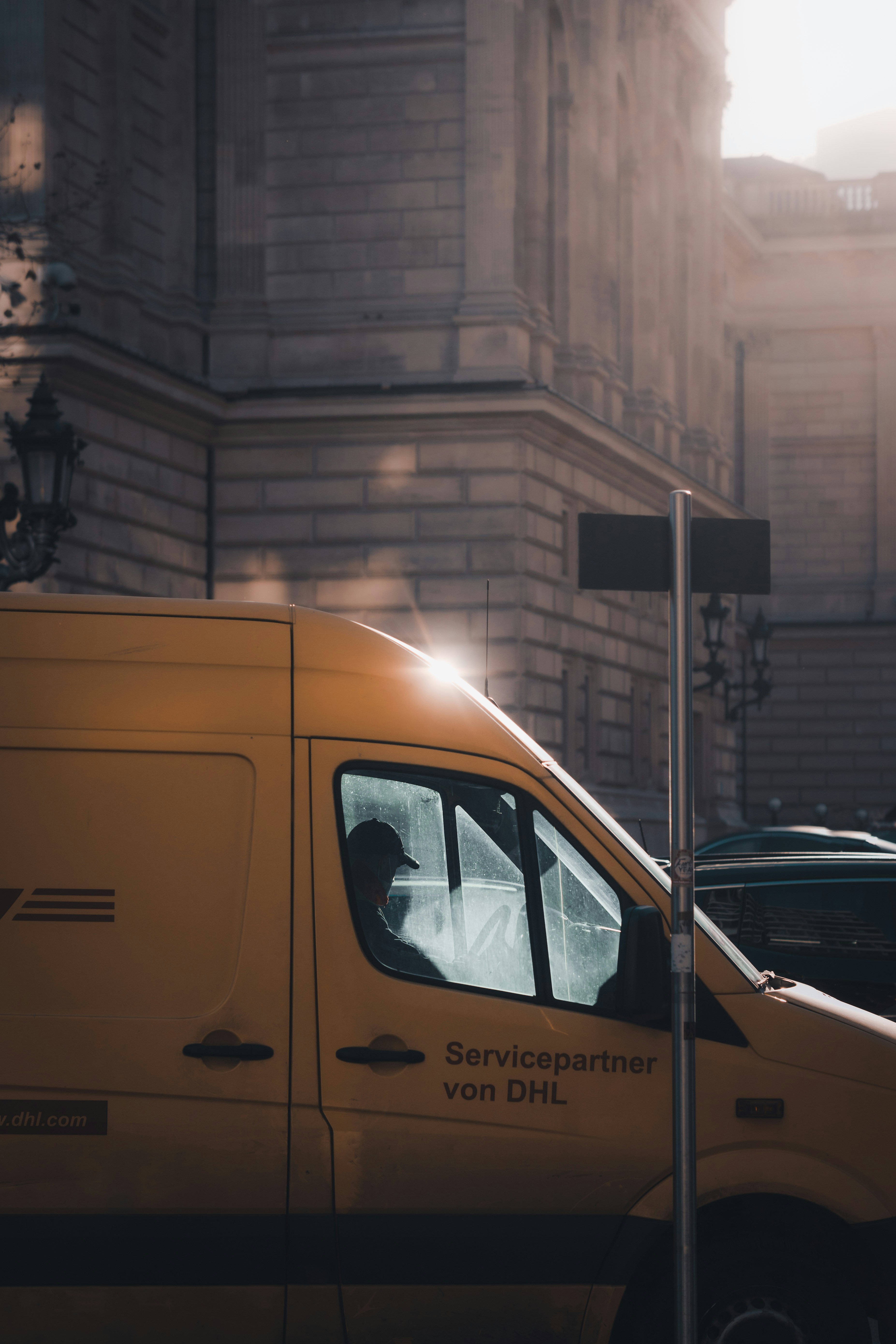 DHL truck driver at work on a bright day.