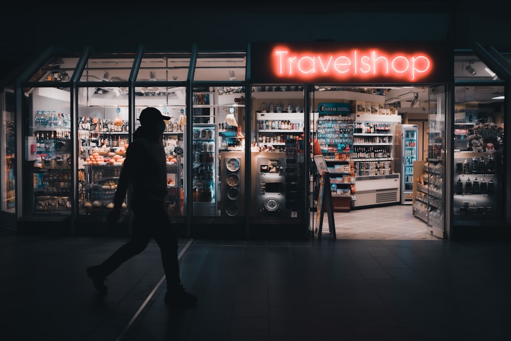 a person walking in front of a travel shop