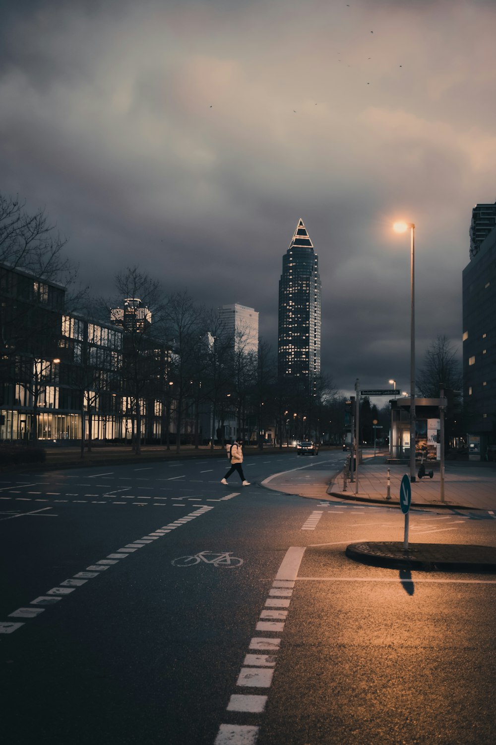 a city street at night with tall buildings in the background