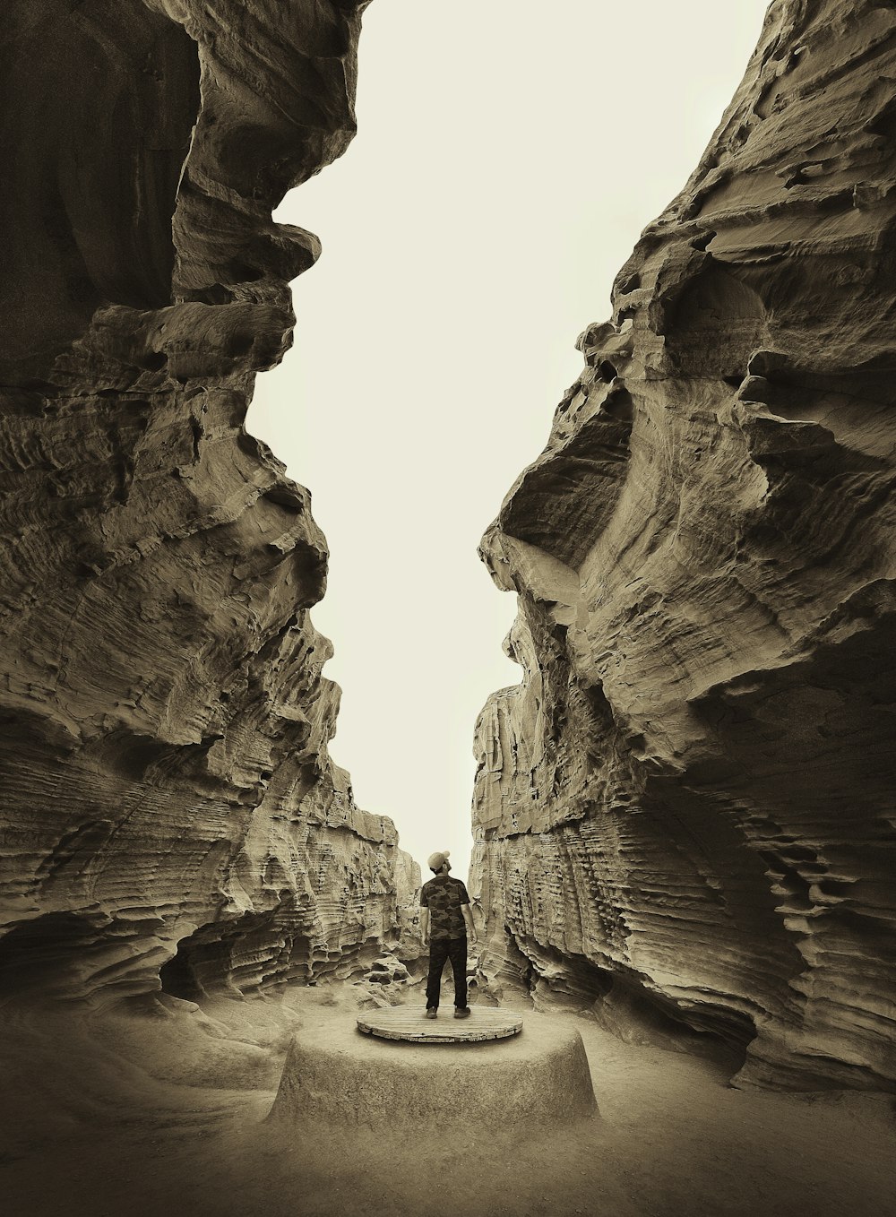 a man standing in a narrow canyon between two large rocks