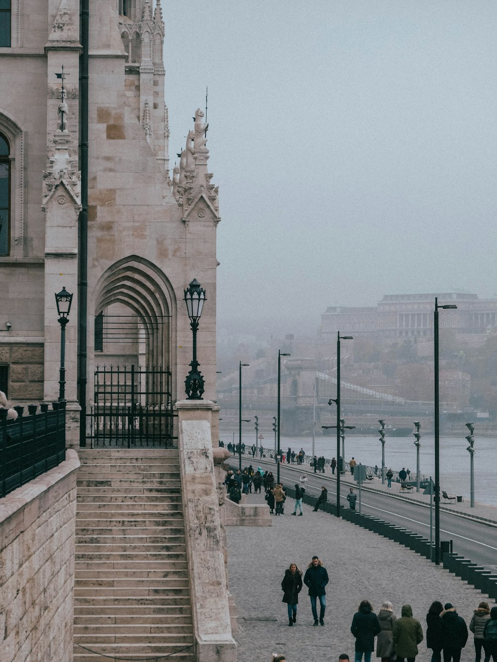 a group of people walking down a street next to a tall building