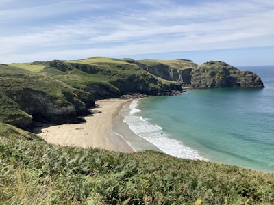 Coastal terrain showcasing sandy beach frontage with calm blue waters.