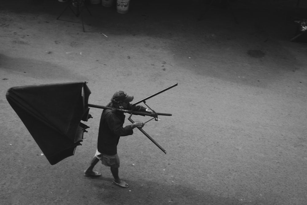 a man carrying a black and white photo of a kite