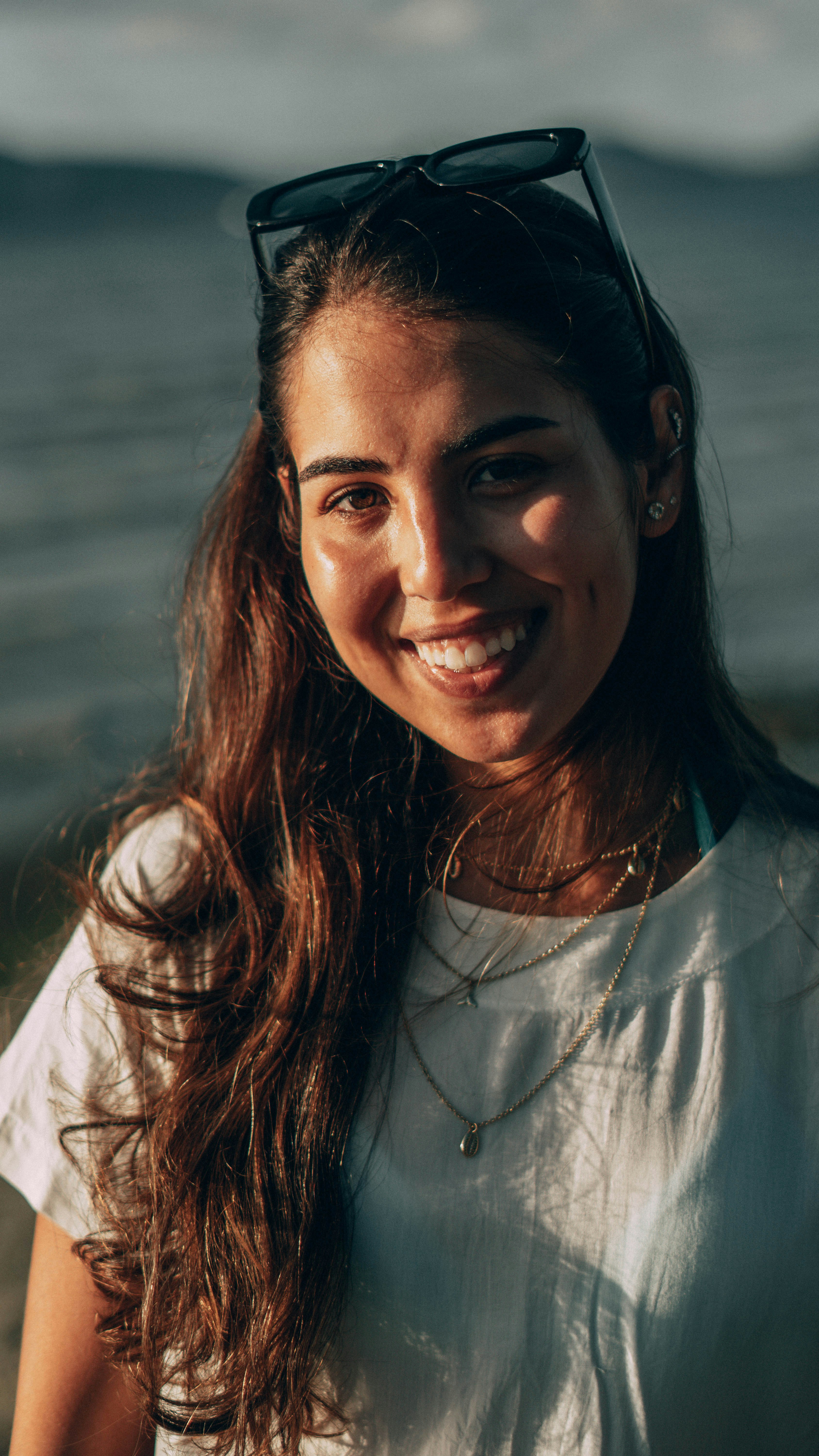 girl smiling and happy with sunglass at the beach in sunsetby Renan Angelo