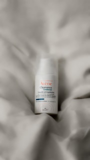 a close up of a bottle of deodorant on a bed