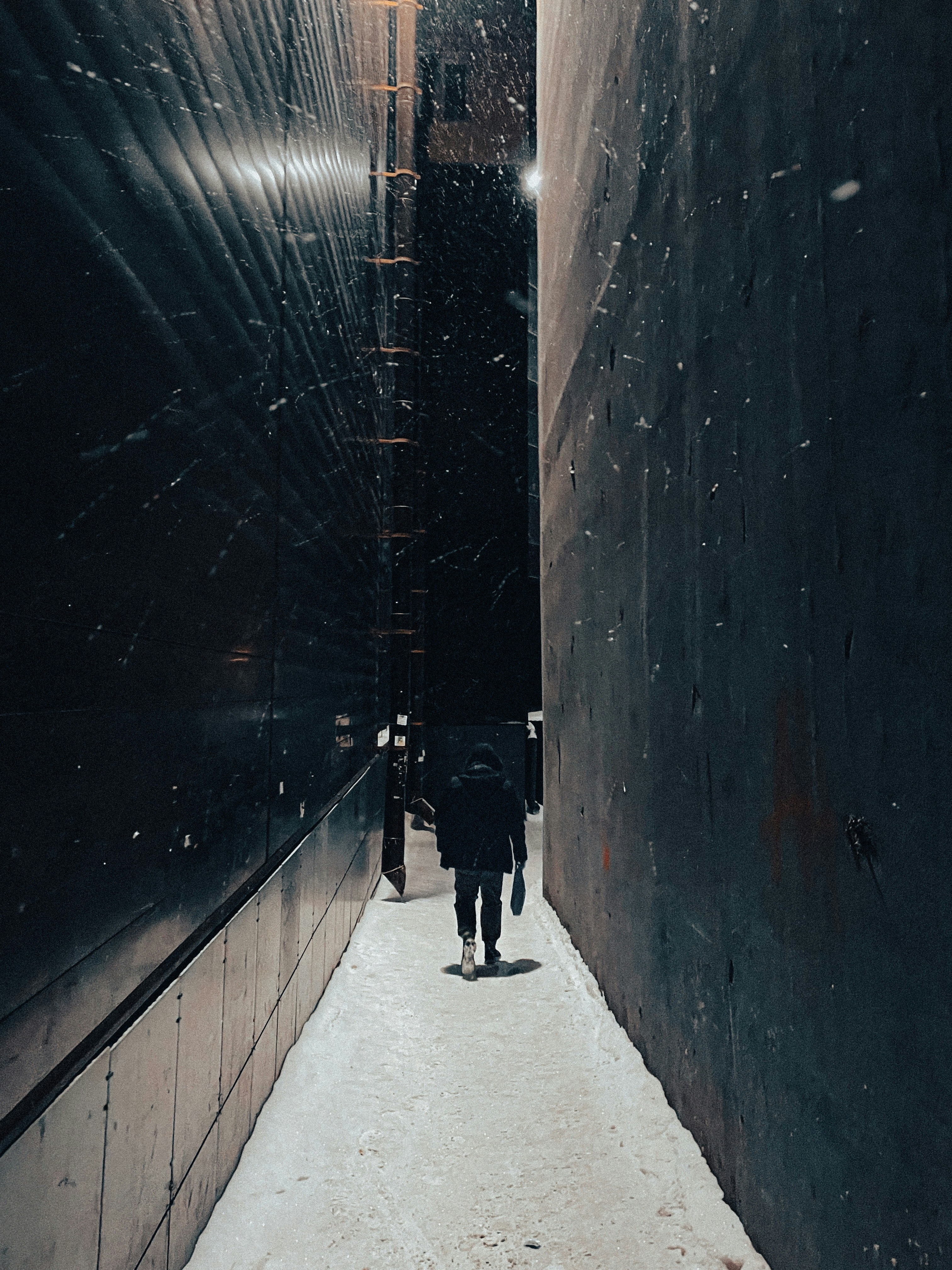 a person walking down a narrow alley way