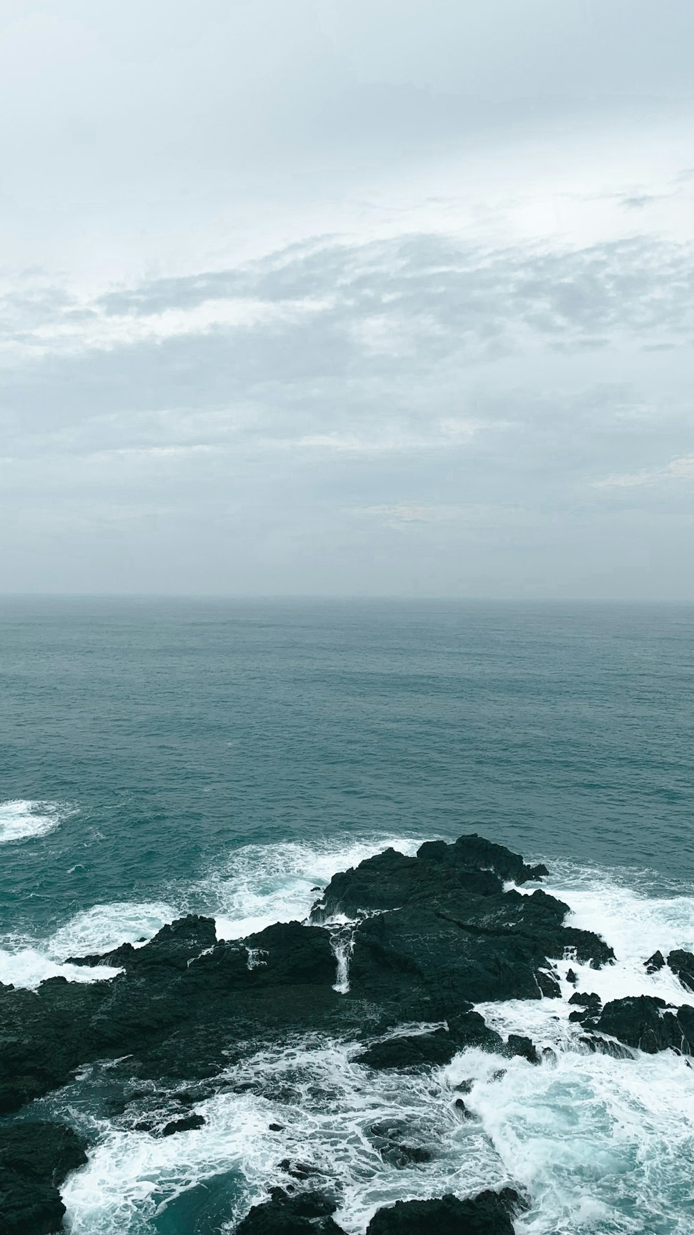 a view of the ocean from a rocky shore