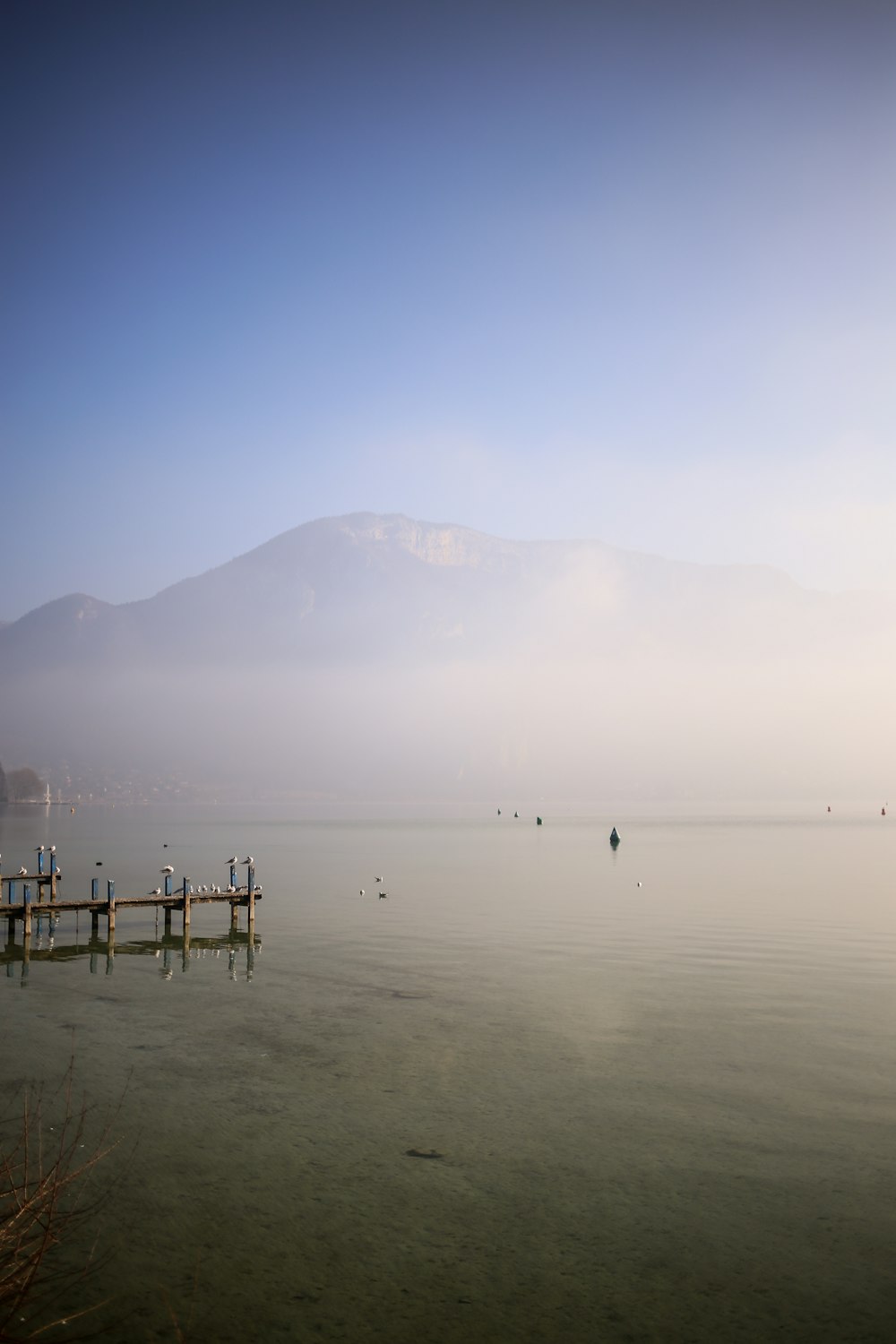 a body of water with a dock and mountains in the background